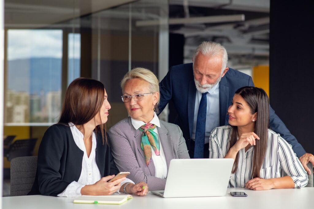 Mature businessman leader mentor talking to diverse colleagues team listening to caucasian ceo.